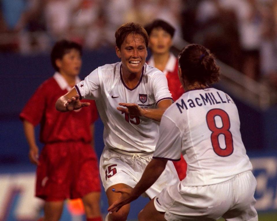 USWNT No 15 runs towards USWNT No 8 MacMillian during a 1999 Women's World Cup match