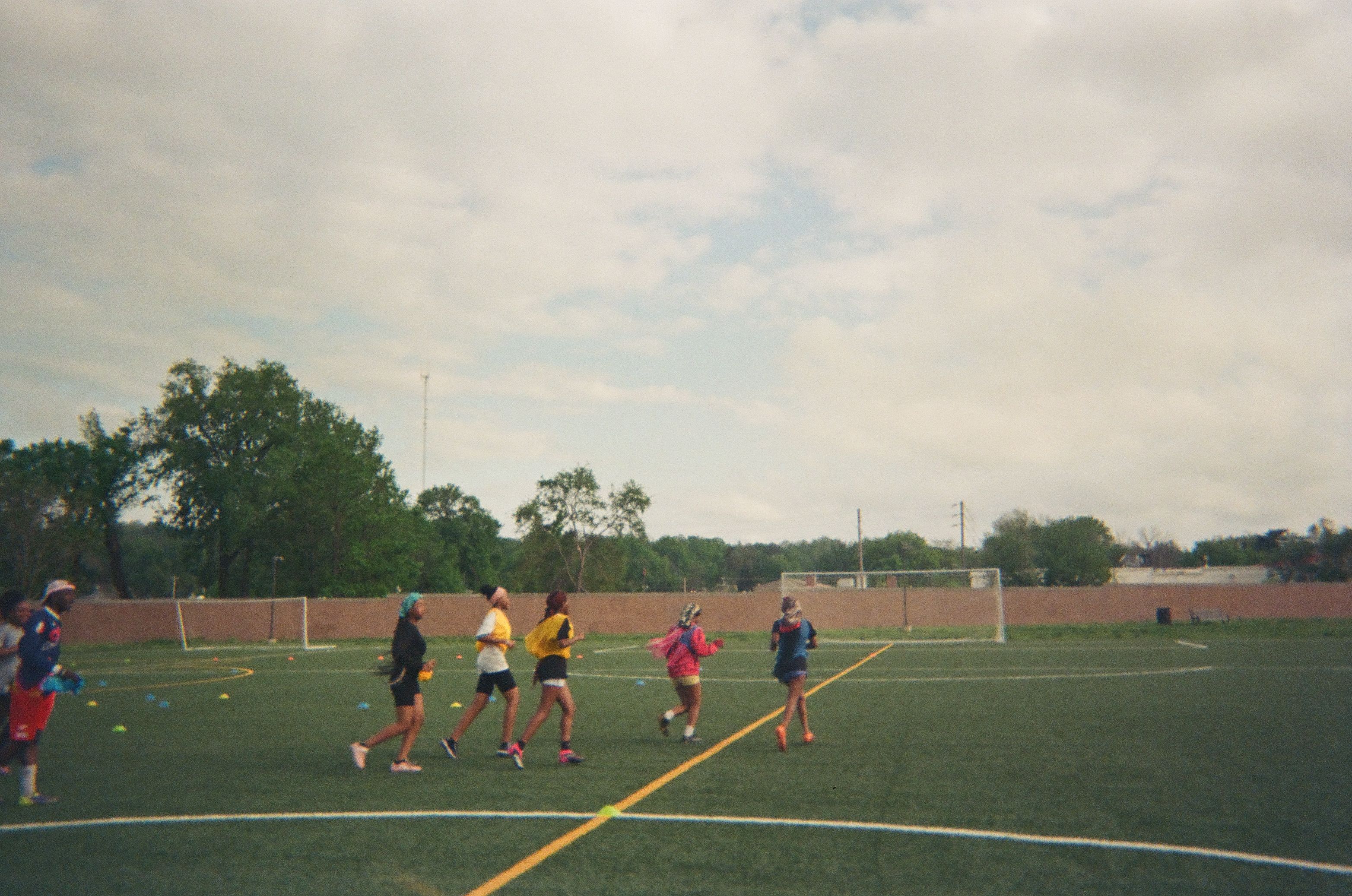 Children take part in a soccer training session on an outdoor field.