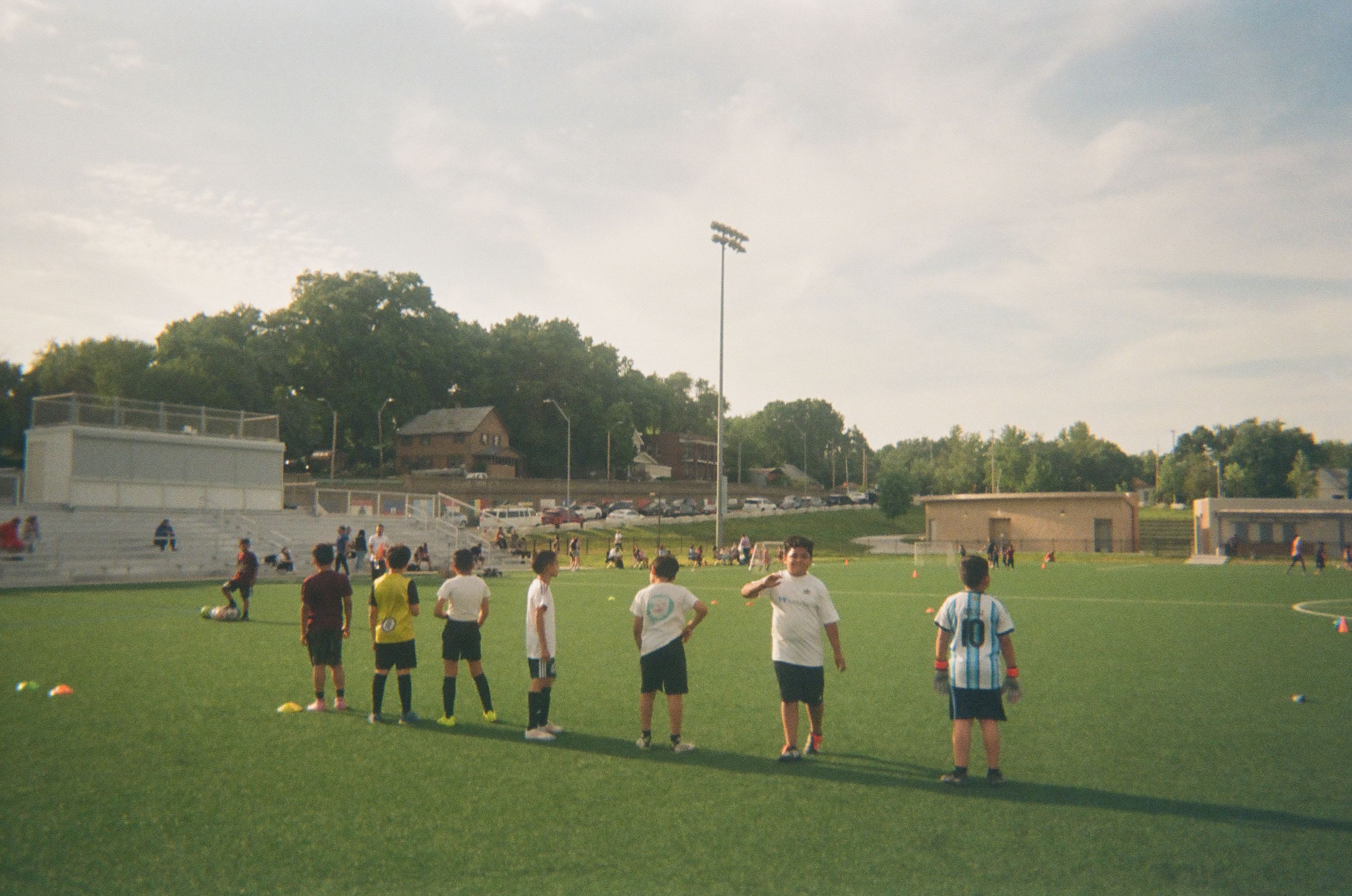 Children gather on an outdoor soccer field during a community training session.