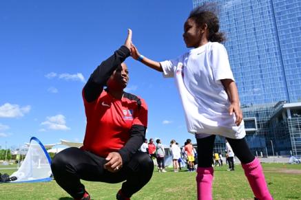 A young soccer player high fives a coach