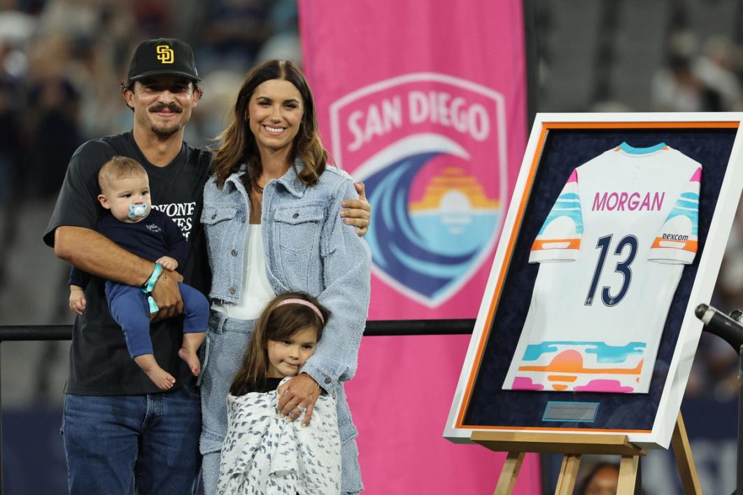 Alex Morgan with her husband, Servando Carrasco, and children during the ceremony to retire her Number 13 jersey with the NWSL club San Diego Wave (Photo by Kevork Djansezian/Getty Images)