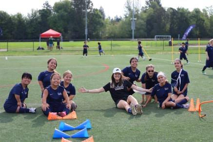 A group of soccer players sit on a field
