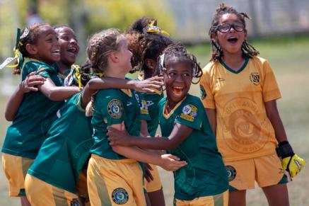 A group of young soccer players celebrates on the field
