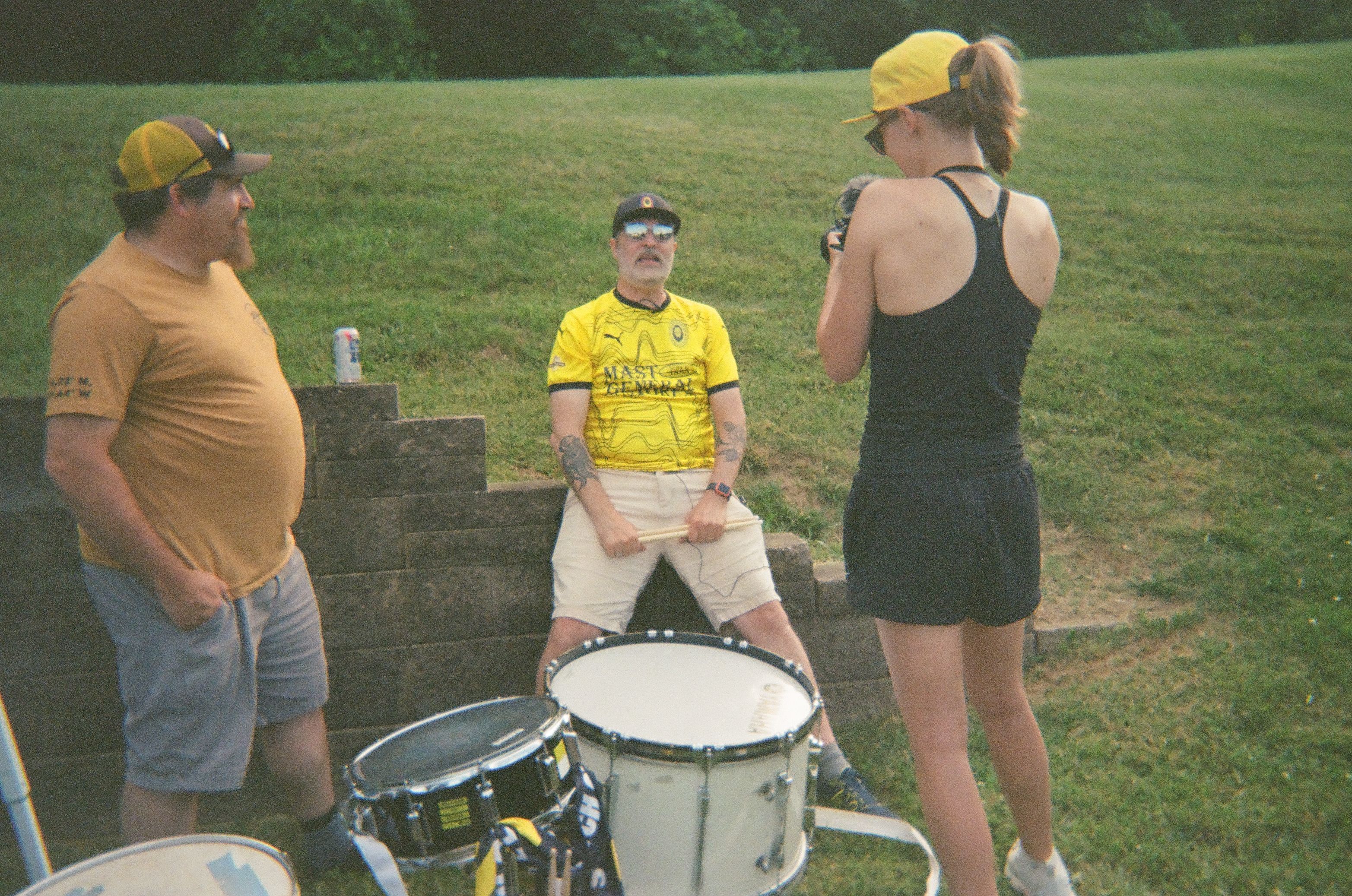 Three soccer supporters beside their drums.