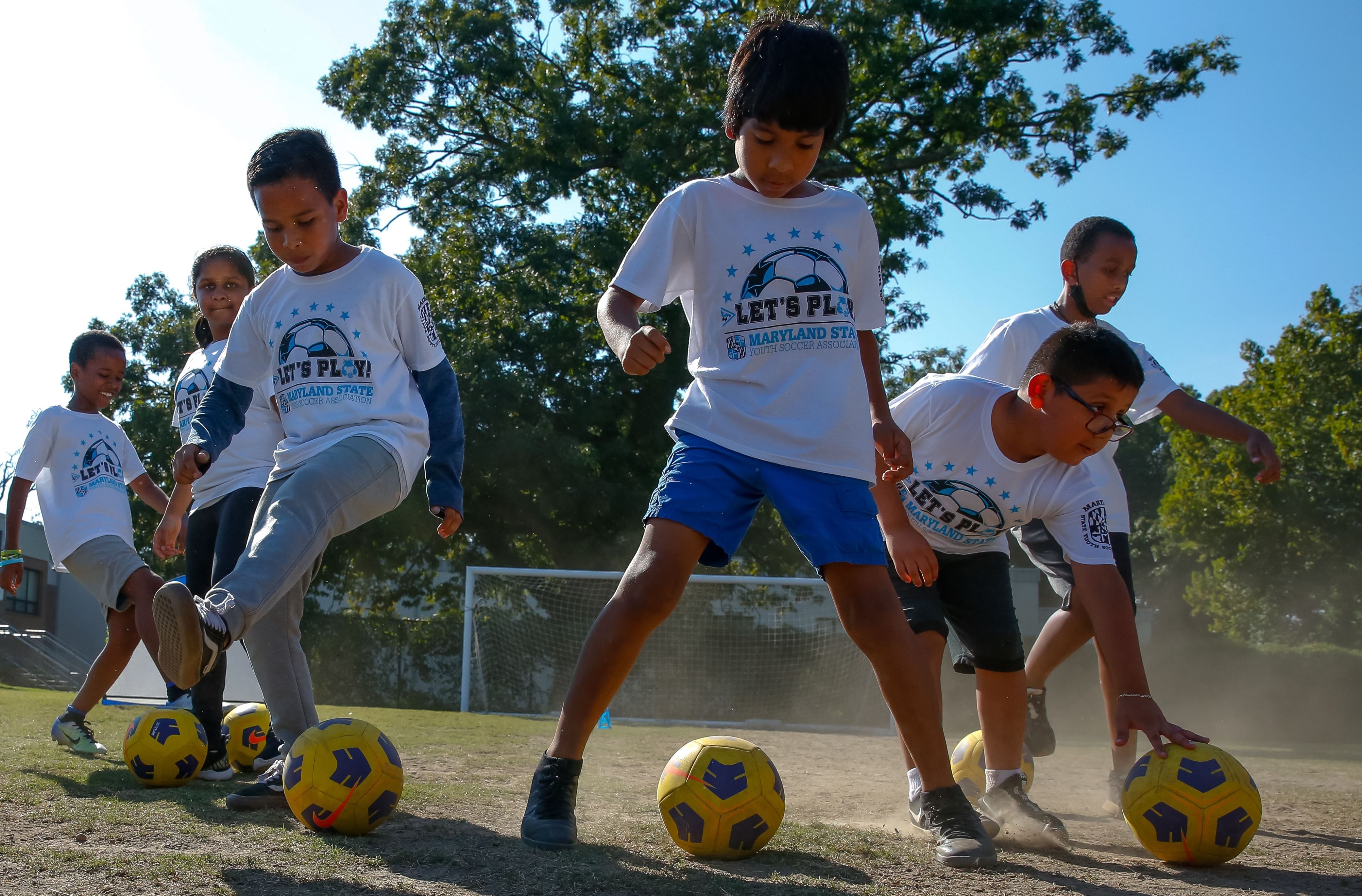 Youth soccer players and coaches posing for a team photo at a Soccer Forward event.