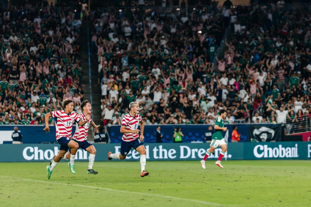 Julian Hall (left) and Sebastian Berhalter (center) chase Cavan Sullivan after Sullivan's goal against Mexico at State Farm Stadium (Photo by Taylor Banner/USSF)