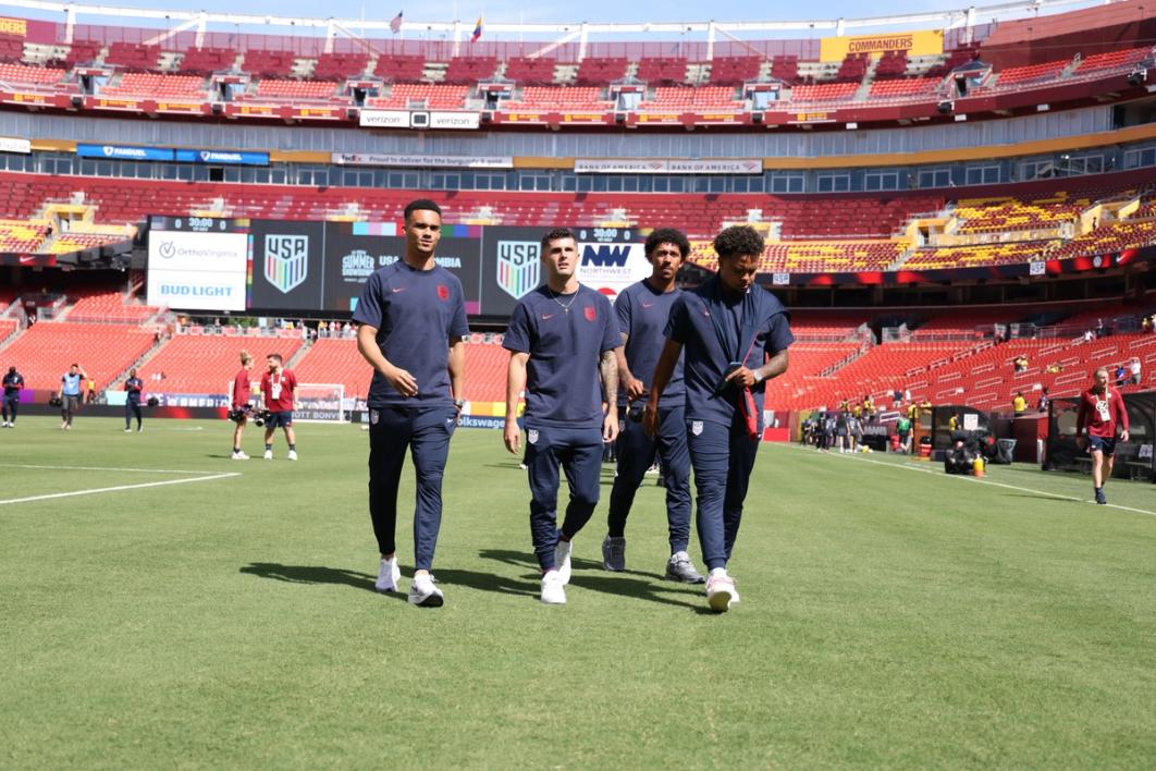 Four usmnt players walking on the field before a match