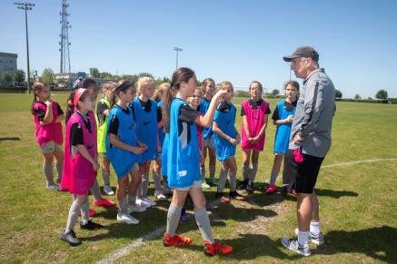 A group of young soccer players with a coach on a field