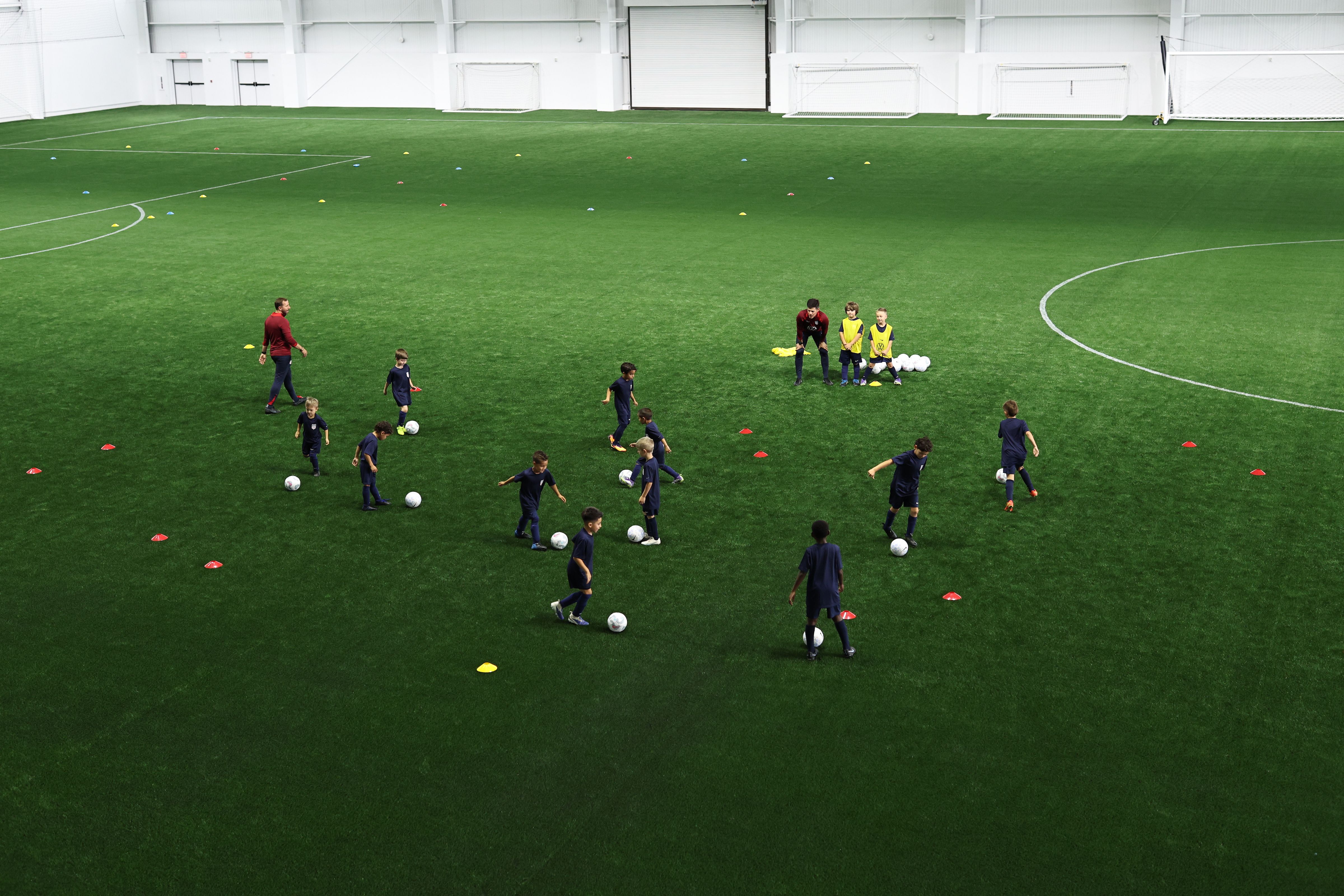 U.S. Soccer coach high-fiving a youth player during an indoor training session