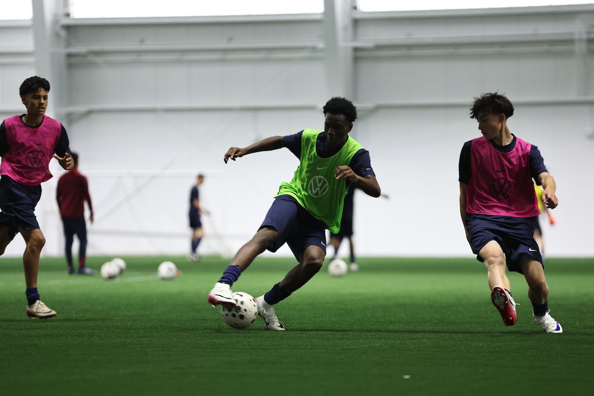Young player drives forward with the ball during a training session.