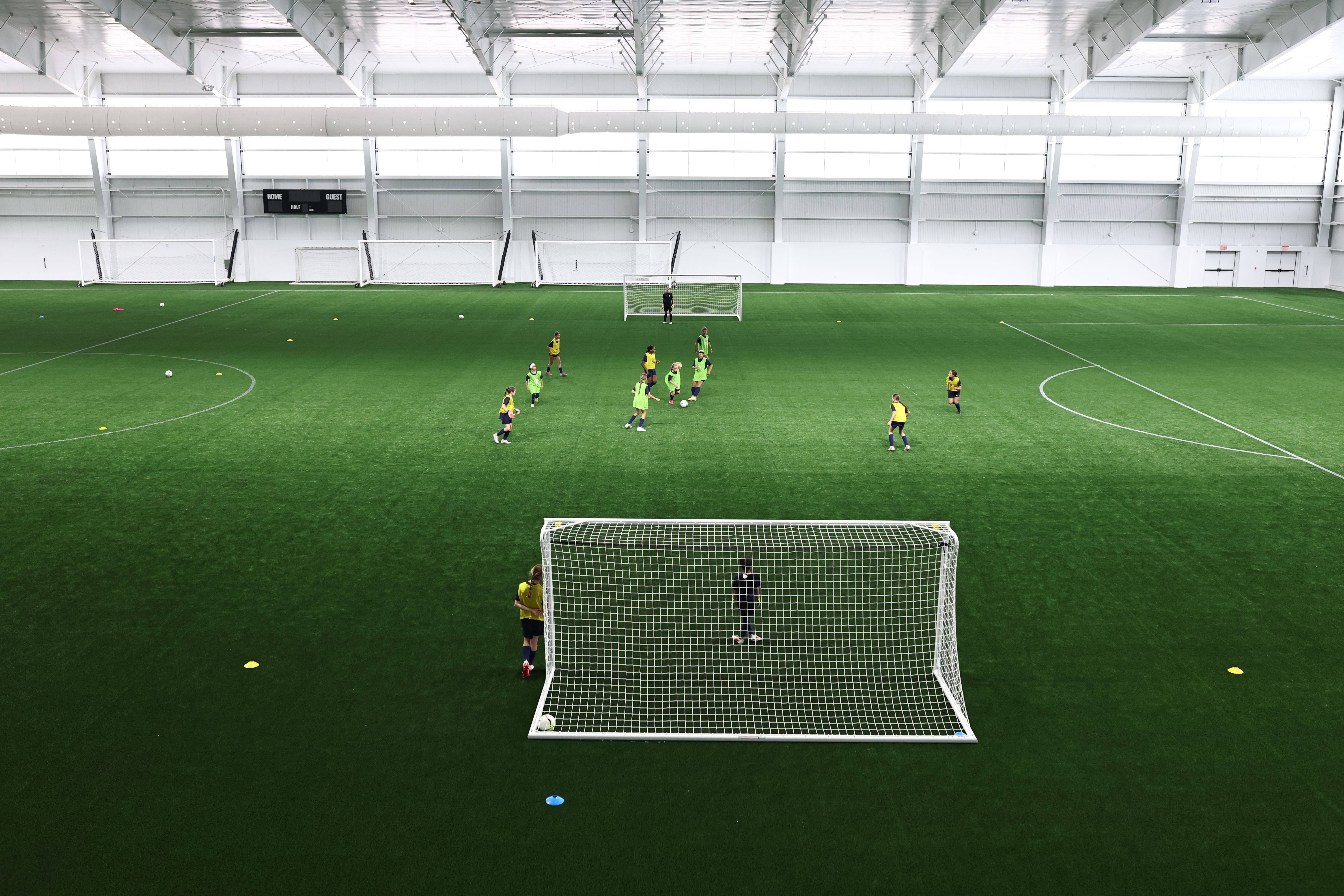 Youth soccer players moving through game play during an indoor training session