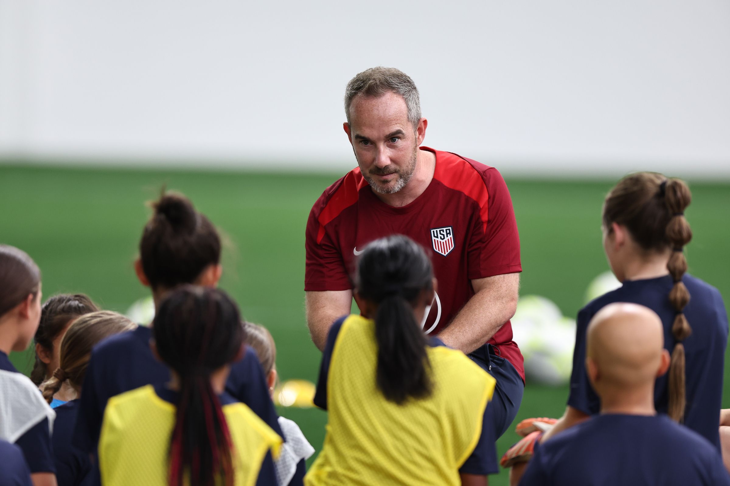 U.S. Soccer coach speaking with youth players during an indoor training session
