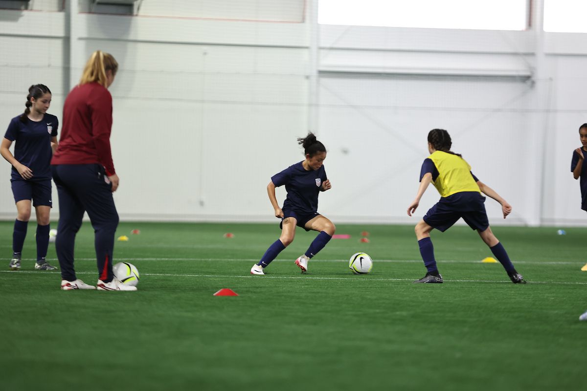 Young players dribble and defend during a small-sided training drill.